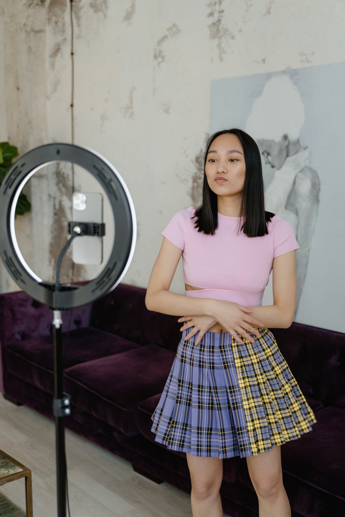 A Girl in Pink Shirt is Standing in Front of the Ring Light